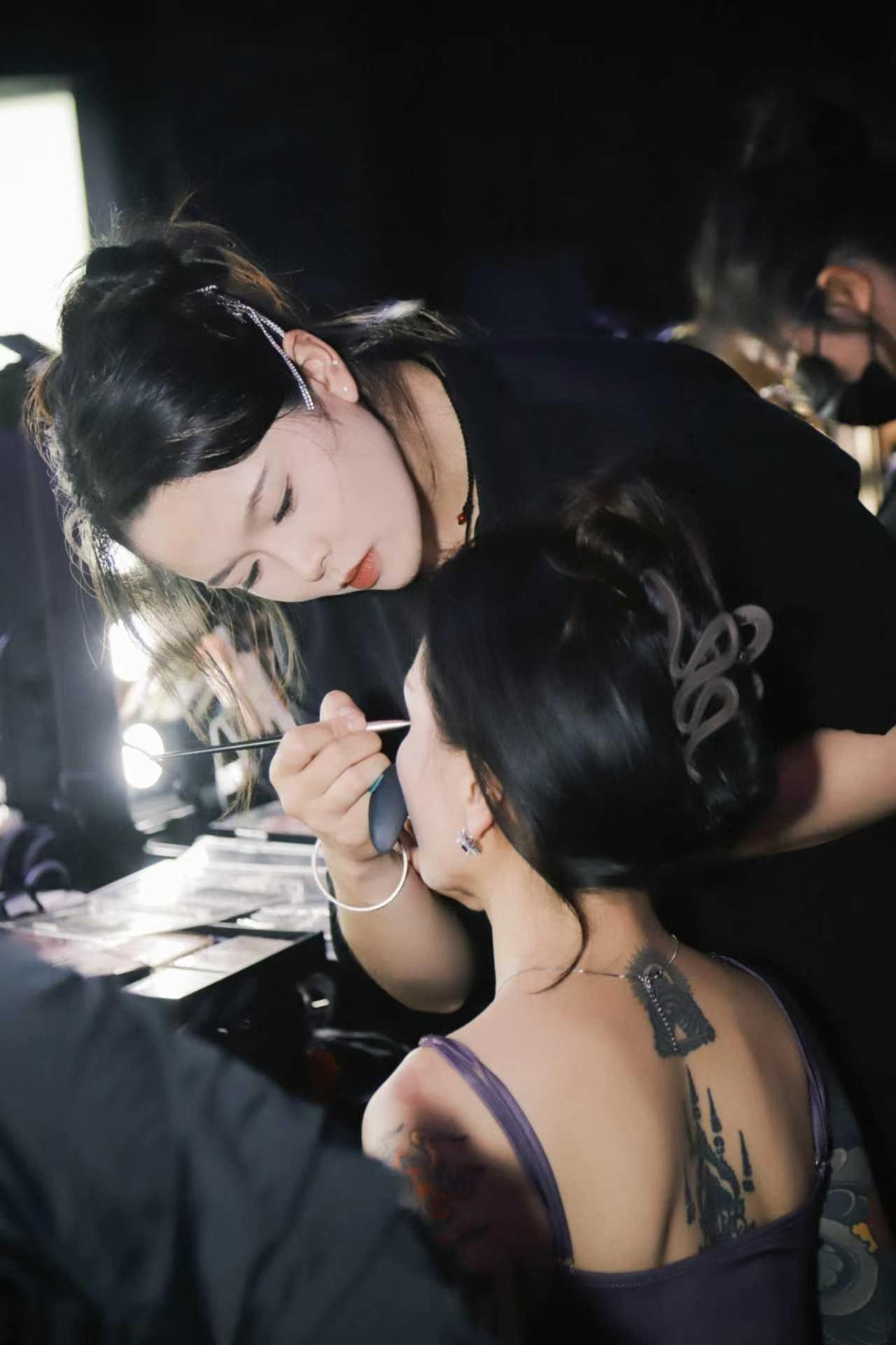 艺丽团队成员在活动后台进行妆面细节处理